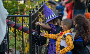 Children receive treats by candy chutes while trick-or-treating for Halloween in Woodlawn Heights on October 31