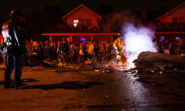 A burning piece of furniture on University Avenue is extinguished by the Lexington Fire Department after a victory by the Kentucky Wildcats over the Florida Gators.