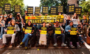 Demonstrators stand behind five young people on a hunger strike near the White House.