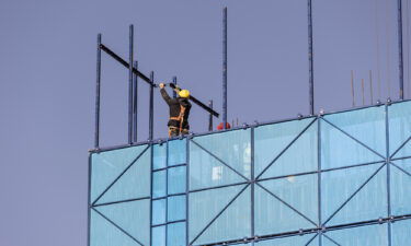 A worker installing safety netting at an apartment block under construction in the Nanchuan area of Xining