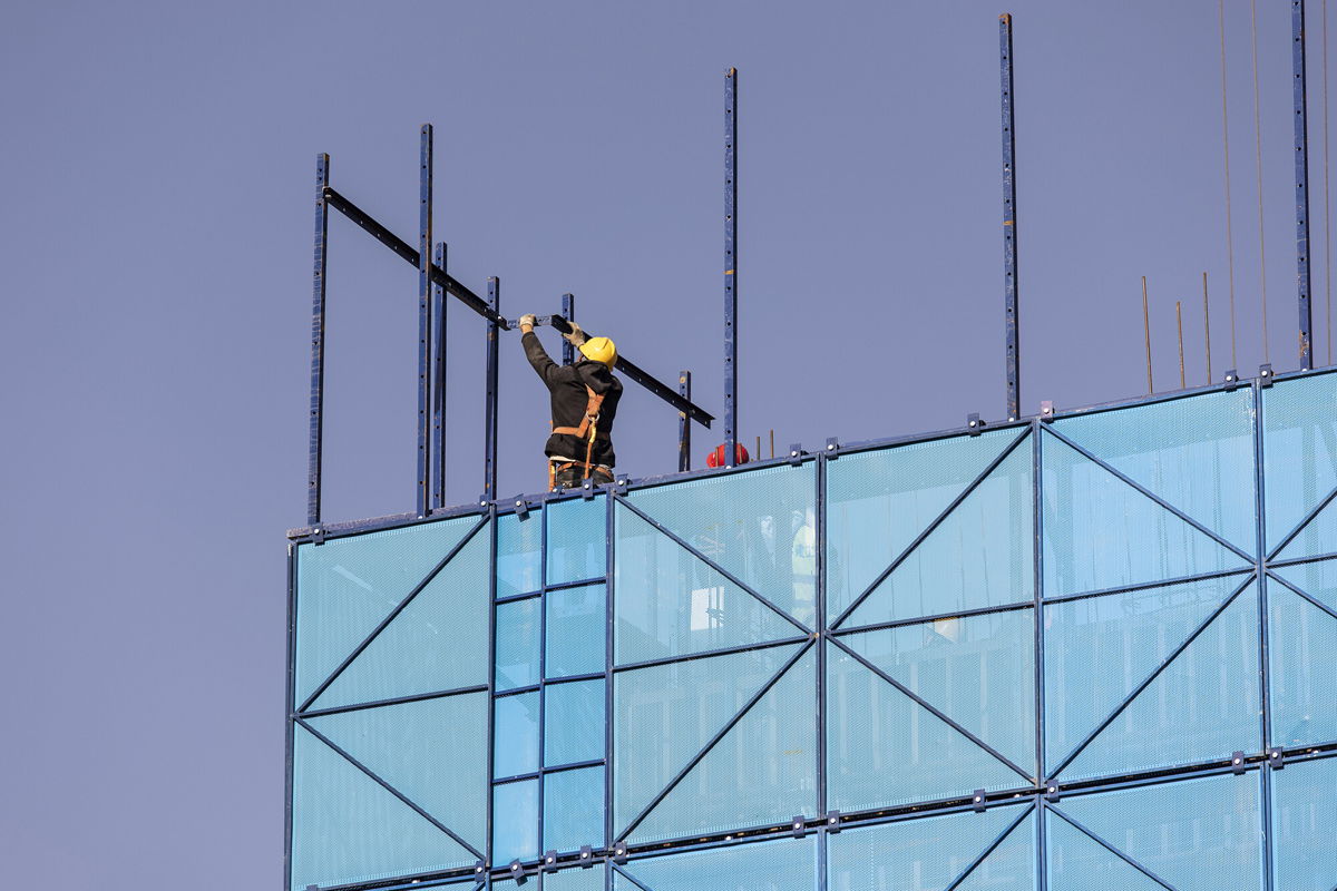 <i>Qilai Shen/Bloomberg/Getty Images</i><br/>A worker installing safety netting at an apartment block under construction in the Nanchuan area of Xining