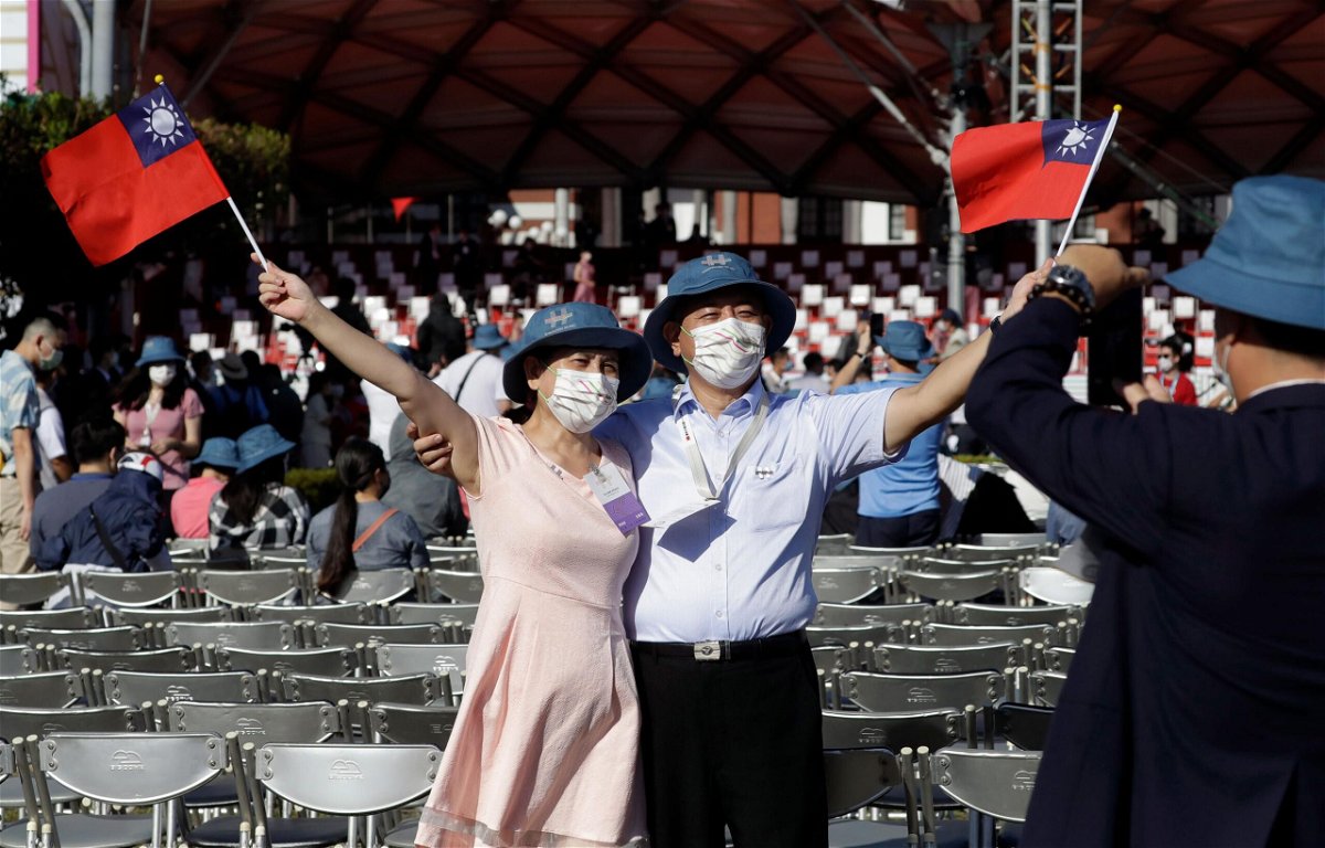 <i>Chiang Ying-ying/AP</i><br/>A couple take a photo with Taiwan national flags during National Day celebrations in front of the Presidential Building in Taipei