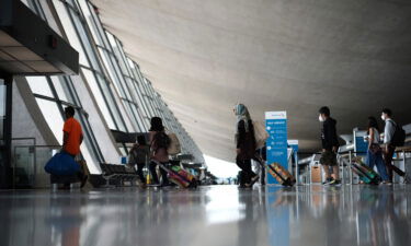 Refugees walk through the departure terminal to a bus at Dulles International Airport after being evacuated from Kabul following the Taliban takeover of Afghanistan on August 31