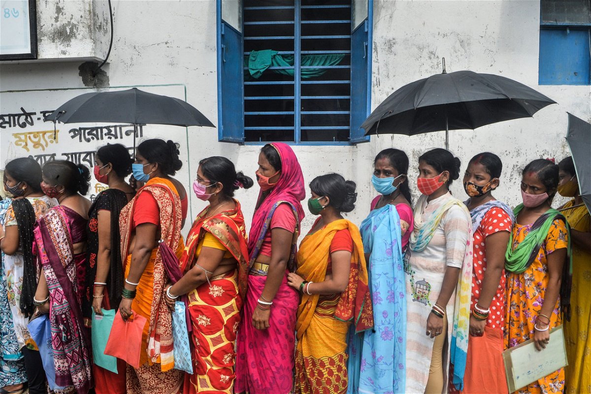 <i>DIPTENDU DUTTA/AFP/AFP via Getty Images</i><br/>Women stand in a queue as they wait to receive a dose of the Covishield vaccine against the Covid-19 at a primary health centre in Siliguri on Aug. 2.