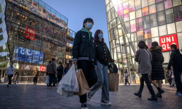 People walk in Sanlitun shopping area on October 16