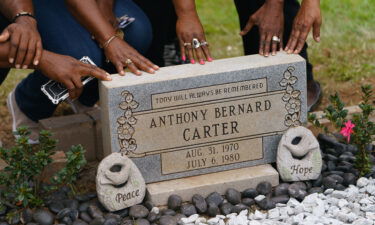 Family members touch the headstone for Anthony Bernard Carter following its unveiling in Hogansville