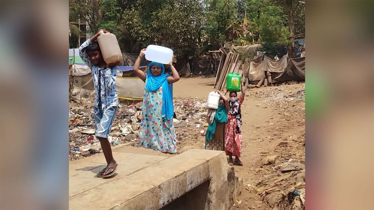 <i>courtesy Anish Yadav</i><br/>Residents carrying cartons of water to the Ambedkar Nagar slum in Mumbai