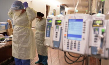 Hospital staff don personal protective equipment before entering the room of a Covid-19 patient at the Northwestern Medicine Lake Forest Hospital ICU in Illinois.