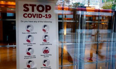 A sign reminds festivalgoers to monitor themselves for possible coronavirus symptoms in the entrance of the Princess of Wales Theatre on day one of the 2021 Toronto International Film Festival