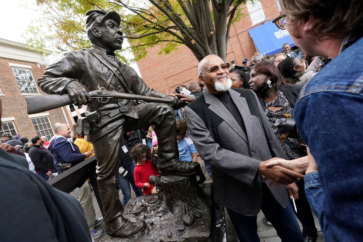 <i>Mark Humphrey/AP</i><br/>Sculptor Joe Howard shakes hands with people who came to see the unveiling of his statue honoring Black men who enlisted in the US Colored Troops.