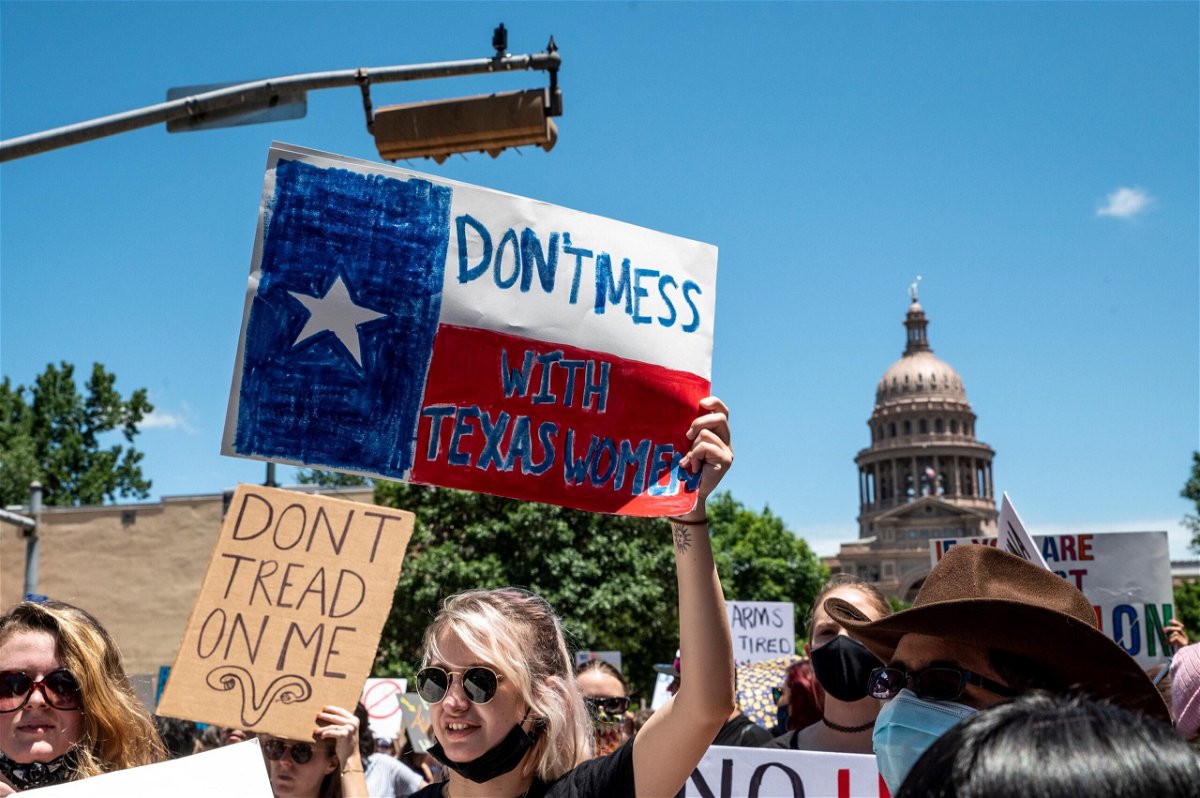 <i>Sergio Flores/Getty Images</i><br/>A federal judge Friday questioned Texas abortion ban's controversial enforcement mechanism. Abortion protesters hold up signs outside the Texas state capitol on May 29