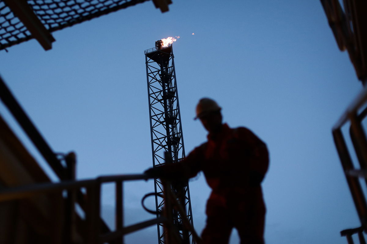 <i>Simon Dawson/Bloomberg/Getty Images</i><br/>An employee walks down stairs in view of a gas burn off venting pipe on the Armada gas condensate platform