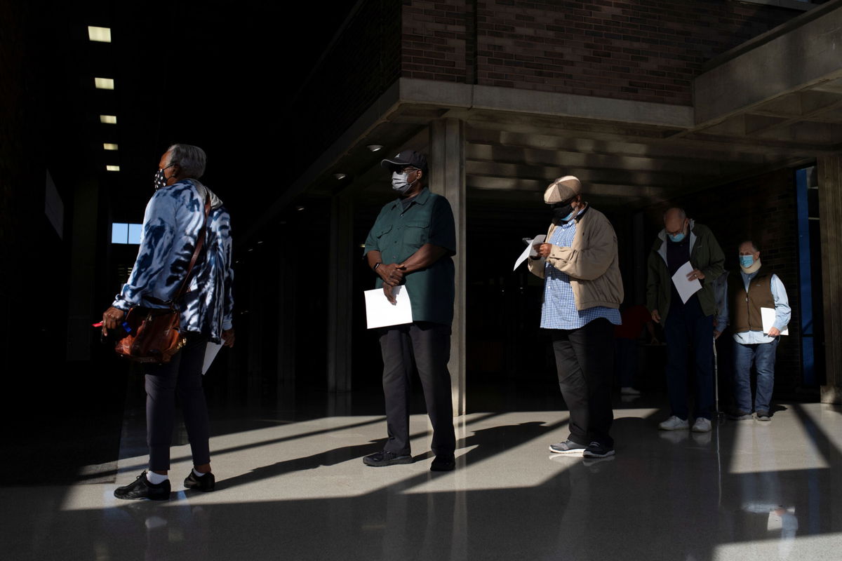 <i>Emily Elconin/Reuters</i><br/>People wait in line with their paperwork to receive their coronavirus booster vaccination during a Pfizer-BioNTech vaccination clinic in Southfield