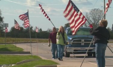Volunteers plant flags along the funeral route of fallen Pontoon Beach Police Officer Tyler Timmins on October 31.