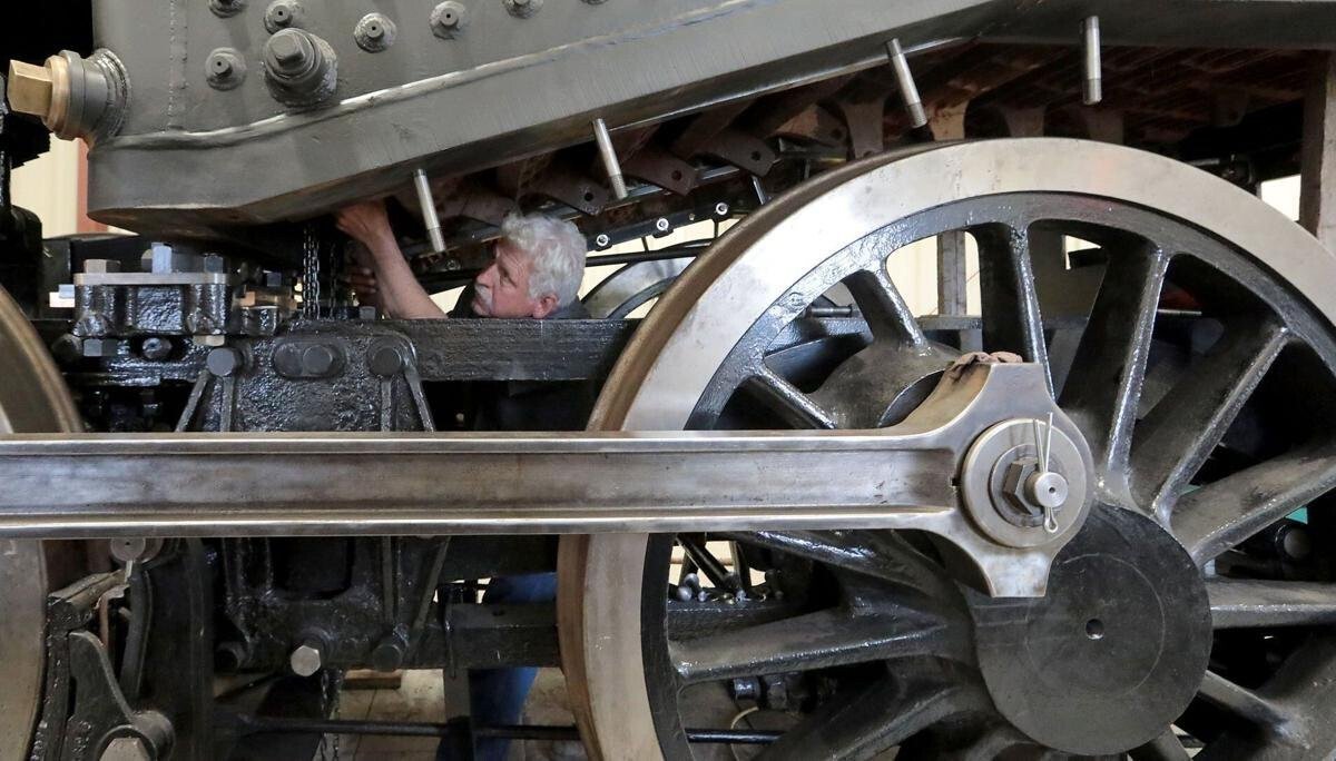 <i>John Hart/Wisconsin State Journal</i><br/>Steve Roudebush works on the underside of a 1907 steam locomotive at SPEC Machine north of Middleton on Thursday.