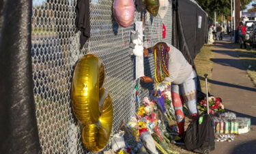 Houston resident J. Washington signs a remembrance board at a makeshift memorial on November 7