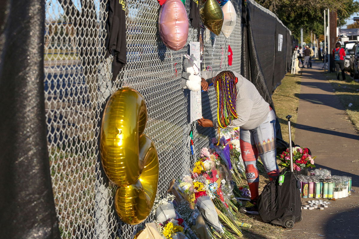 <i>Thomas Shea/AFP/Getty Images</i><br/>Houston resident J. Washington signs a remembrance board at a makeshift memorial on November 7