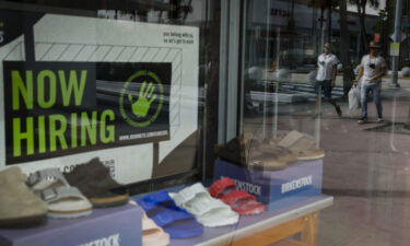 America's job market is showing signs of strength. A "Now Hiring" sign is shown outside a shoe store in Miami