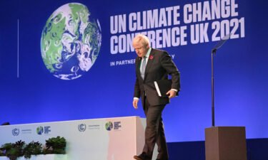 Britain's Prime Minister Boris Johnson walks off of the stage after speaking at COP26 on Monday.
