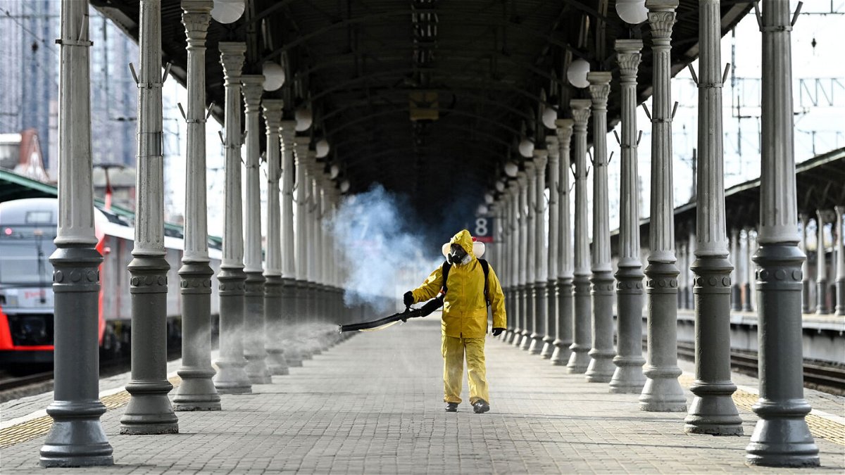 <i>KIRILL KUDRYAVTSEV/AFP via Getty Images</i><br/>A worker is seen disinfecting Moscow's Belorussky railway station. Russia is battling its worst spike in Covid-19 cases since the pandemic began.