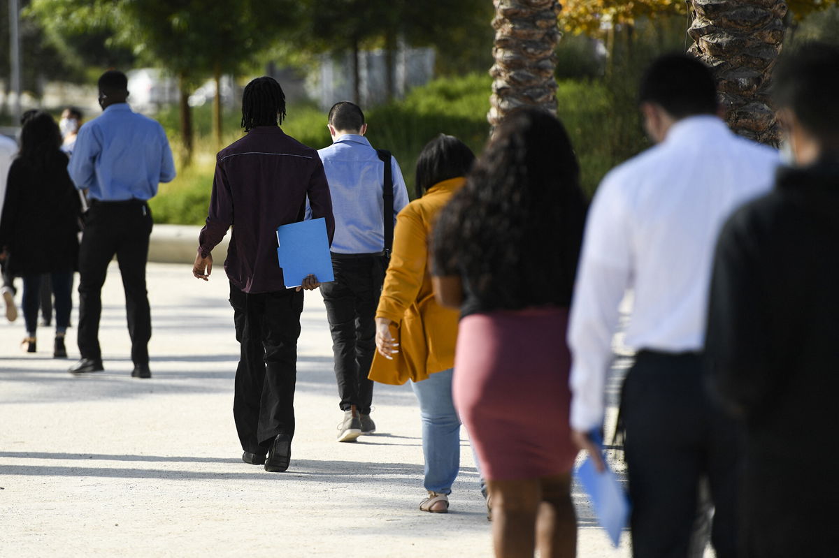 <i>Patrick T. Fallon/AFP/Getty Images</i><br/>People wait in line to attend a job fair for employment with SoFi Stadium and Los Angeles International Airport employers