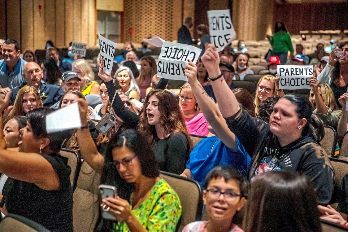 <i>Alexandra Wimley/Pittsburgh Post-Gazette/AP</i><br/>People hold signs and chant during a meeting of the North Allegheny School District school board regarding the district's mask policy