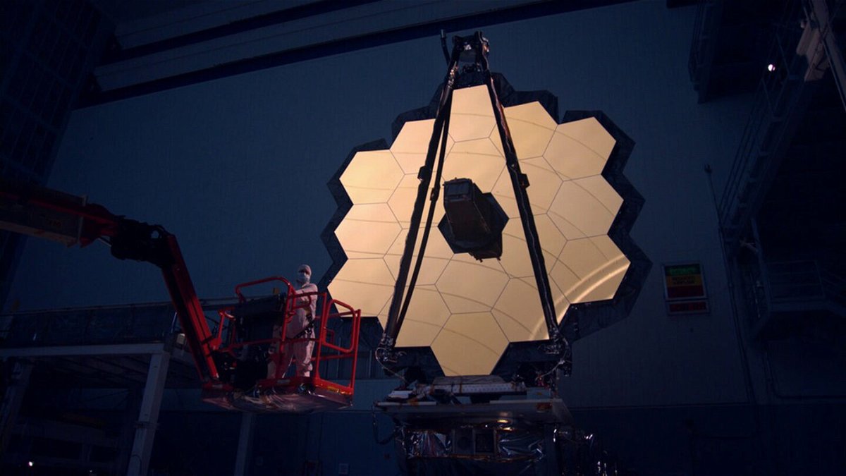 <i>NASA Goddard Space Flight Center</i><br/>The James Webb Space Telescope primary mirror illuminated in a dark cleanroom.
