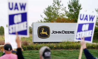 FILE - Members of the United Auto Workers strike outside of a John Deere plant