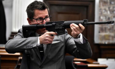 Assistant District Attorney Thomas Binger holds Kyle Rittenhouse's gun as he gives the state's closing argument on Monday