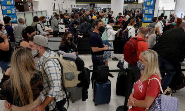 People wait in the line to clear through the TSA checkpoint at Miami International Airport in Florida on November 24.