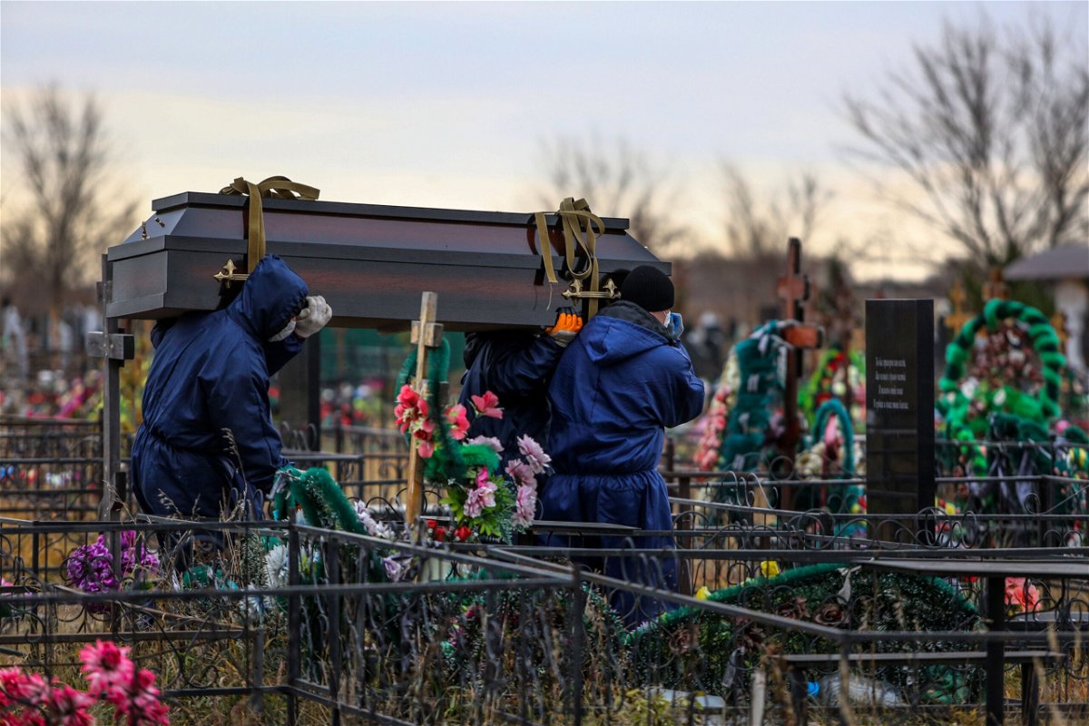 <i>AP</i><br/>Gravediggers carry a coffin of a Covid-19 victim at the Novo-Yuzhnoye cemetery