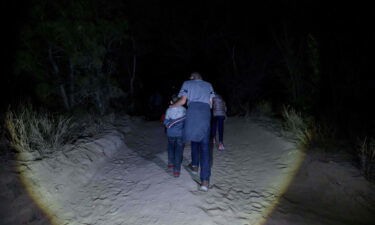 Migrants from Central America make their way along a track in the border city of Roma