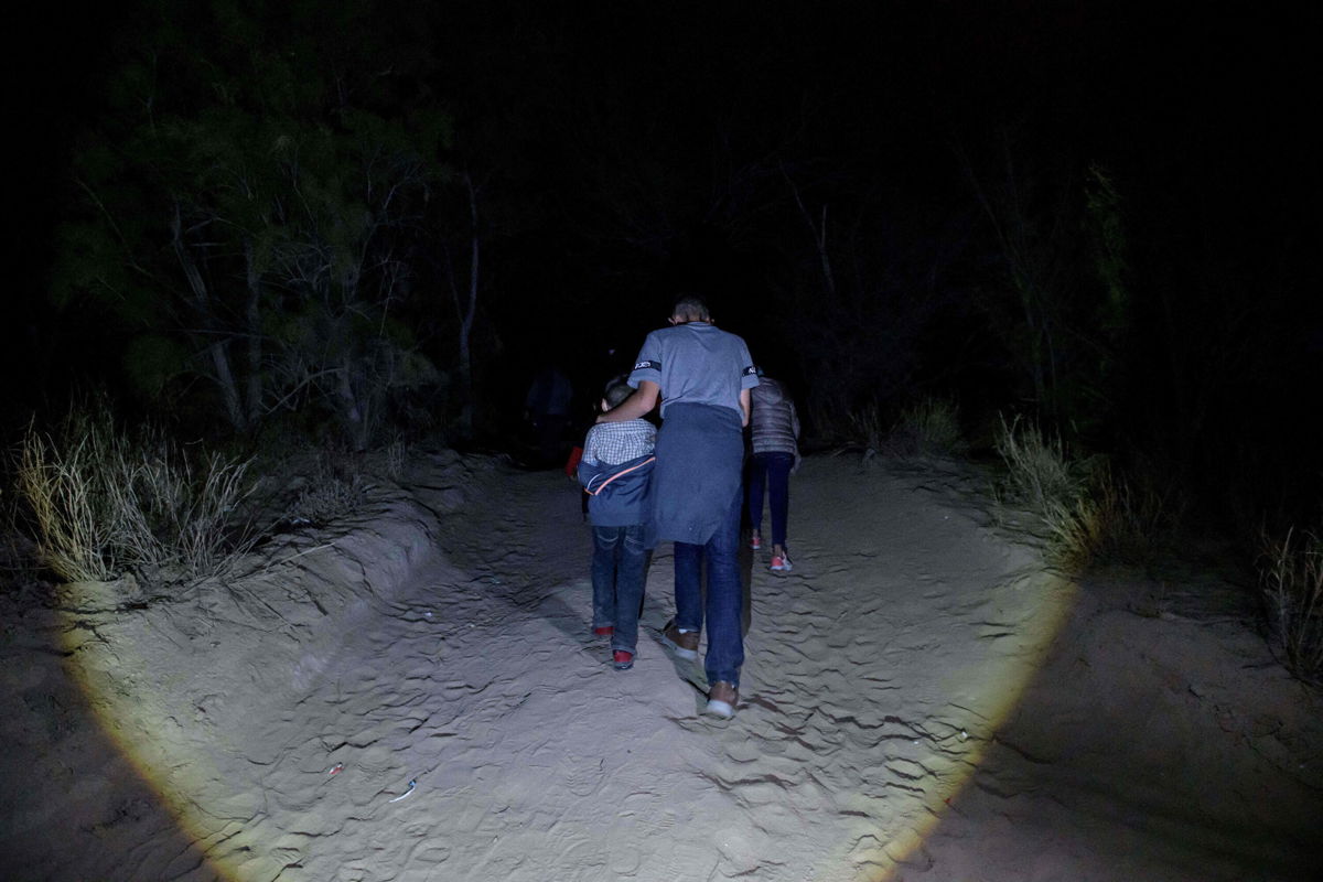 <i>ED JONES/AFP via Getty Images</i><br/>Migrants from Central America make their way along a track in the border city of Roma