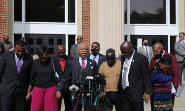 Rev. Al Sharpton (center) prays with Wanda Cooper-Jones and Marcus Arbery in front of the Glynn County Courthouse on November 10.