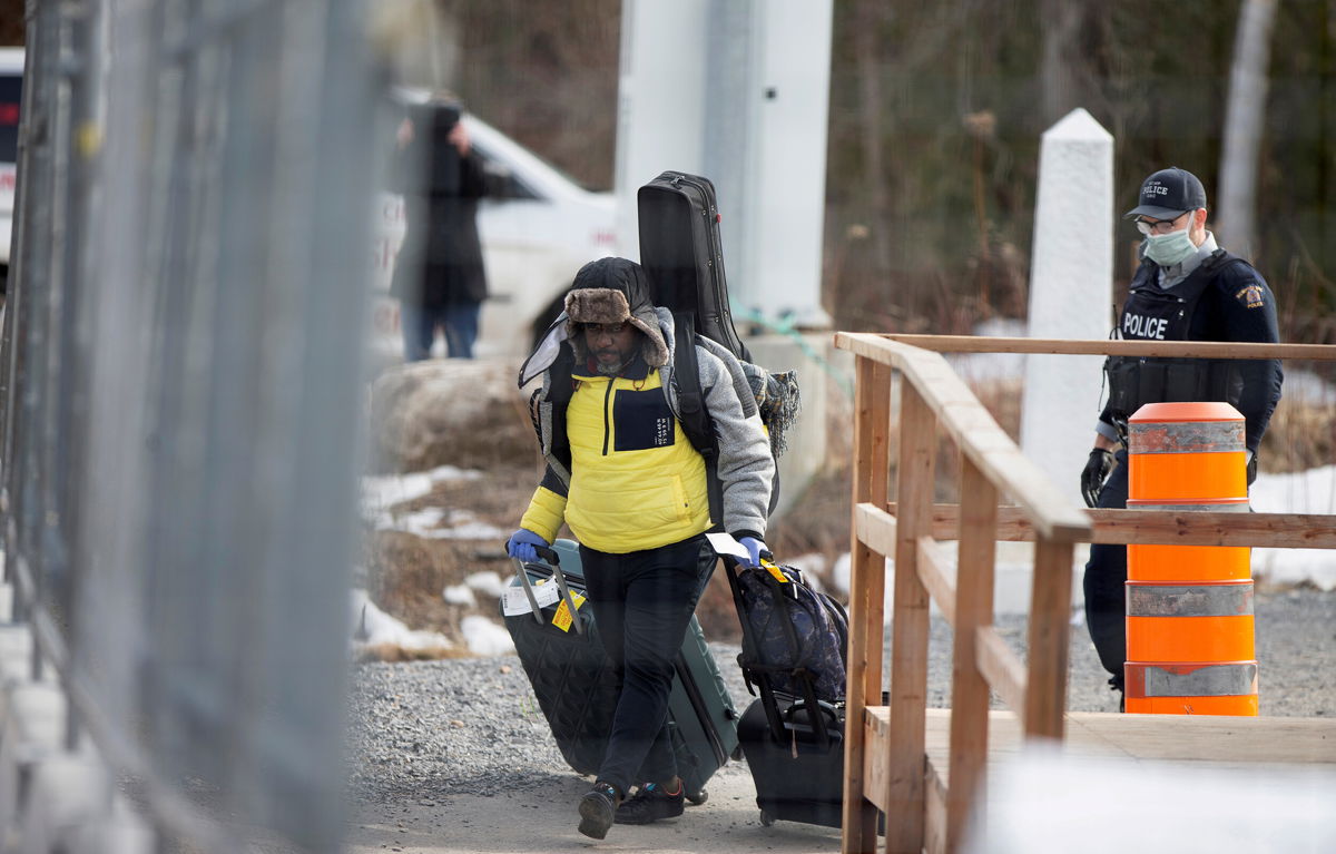 <i>Christinne Muschi/Reuters/FILE</i><br/>An asylum seeker crosses the border from New York into Canada followed by a Royal Canadian Mounted Police (RCMP) officer in Hemmingford