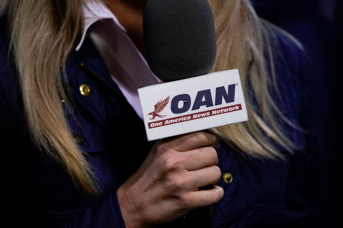 <i>Drew Angerer/Getty Images</i><br/>A reporter with One America News Network works at a campaign rally with President Donald Trump at Newport News/Williamsburg International Airport in September of 2020 in Newport News