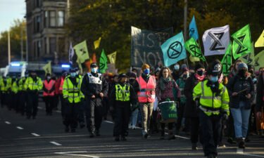 Activists are seen being escorted by police during an Extinction Rebellion protest on Thursday in Glasgow.
