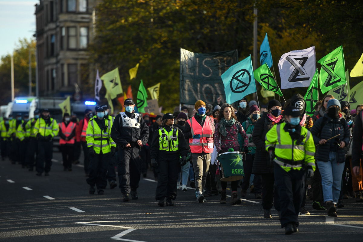 <i>Peter Summers/Getty Images</i><br/>Activists are seen being escorted by police during an Extinction Rebellion protest on Thursday in Glasgow.