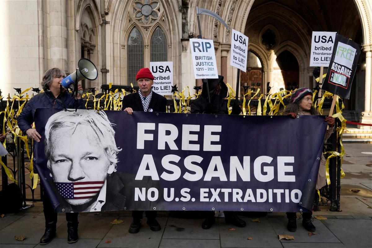 <i>Niklas Halle'n/AFP/Getty Images</i><br/>Supporters of WikiLeaks founder Julian Assange hold placards outside the Royal Courts of Justice in London on December 10.