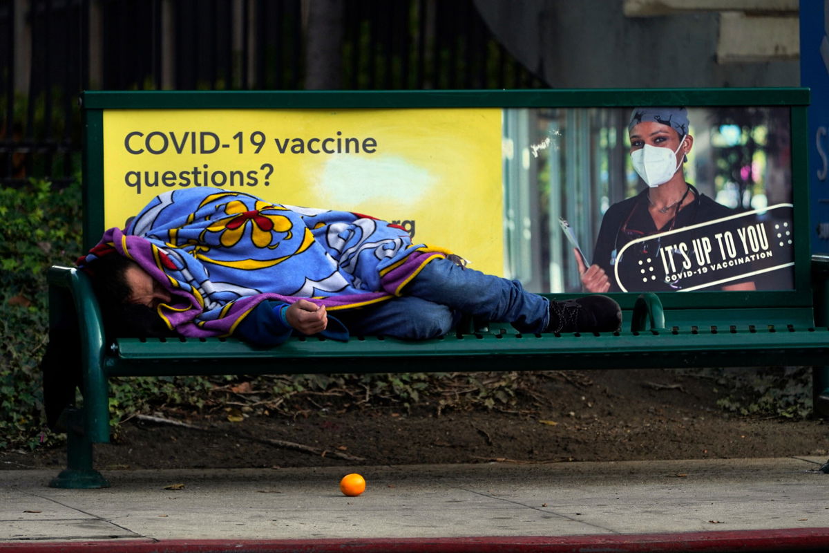 <i>Damian Dovarganes/AP</i><br/>A homeless person sleeps on a bench in downtown Los Angeles