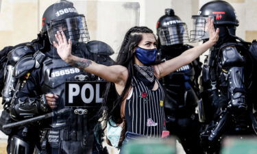 Riot police detain a demonstrator during protests against police brutality in Bogota on September 21