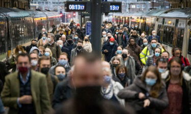 Commuters disembark a train at Kings Cross station at rush hour in London
