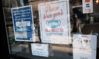 An appeals court ruled Friday that the government can enforce a vaccine-or-testing rule for companies with more than 100 employees. A sign on the door of a coffee shop in New York City asks for proof of vaccination on December 13.