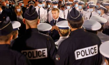 French President Emmanuel Macron talks to police officers during a visit to a police station in northern Marseille on September 1.