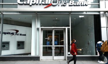 A woman wearing a face mask walks past the Capital One Bank branch in Midtown. Capital One announced it is getting rid of all fees for overdrafts and non-sufficient funds. It will also continue to allow customers to get free overdraft protection on their accounts.