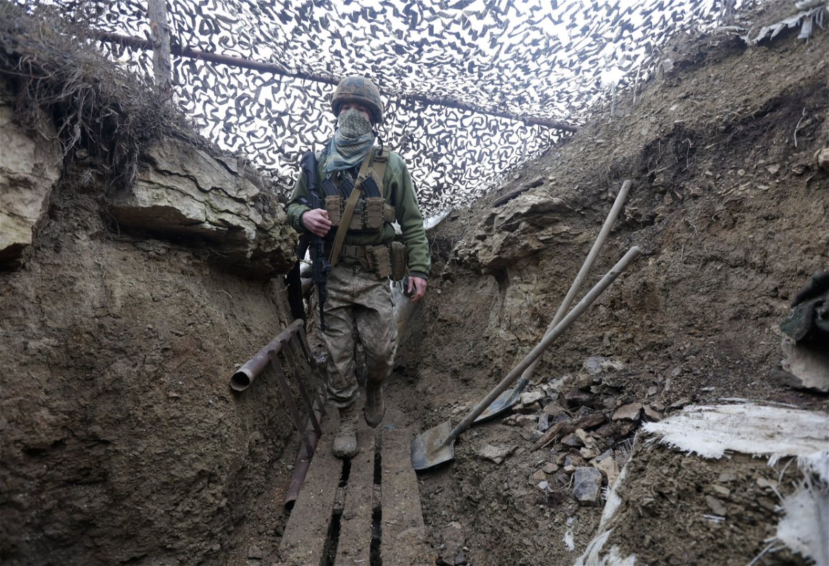 <i>Andriy Dubchak/AP</i><br/>Ukrainian soldiers walks under a camouflage net in a trench on the line of separation from pro-Russian rebels near Debaltsevo