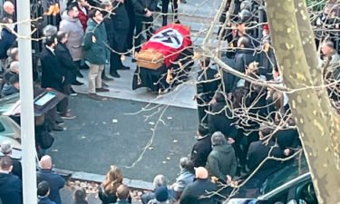 People gathered around a swastika-covered casket outside the St. Lucia church in Rome