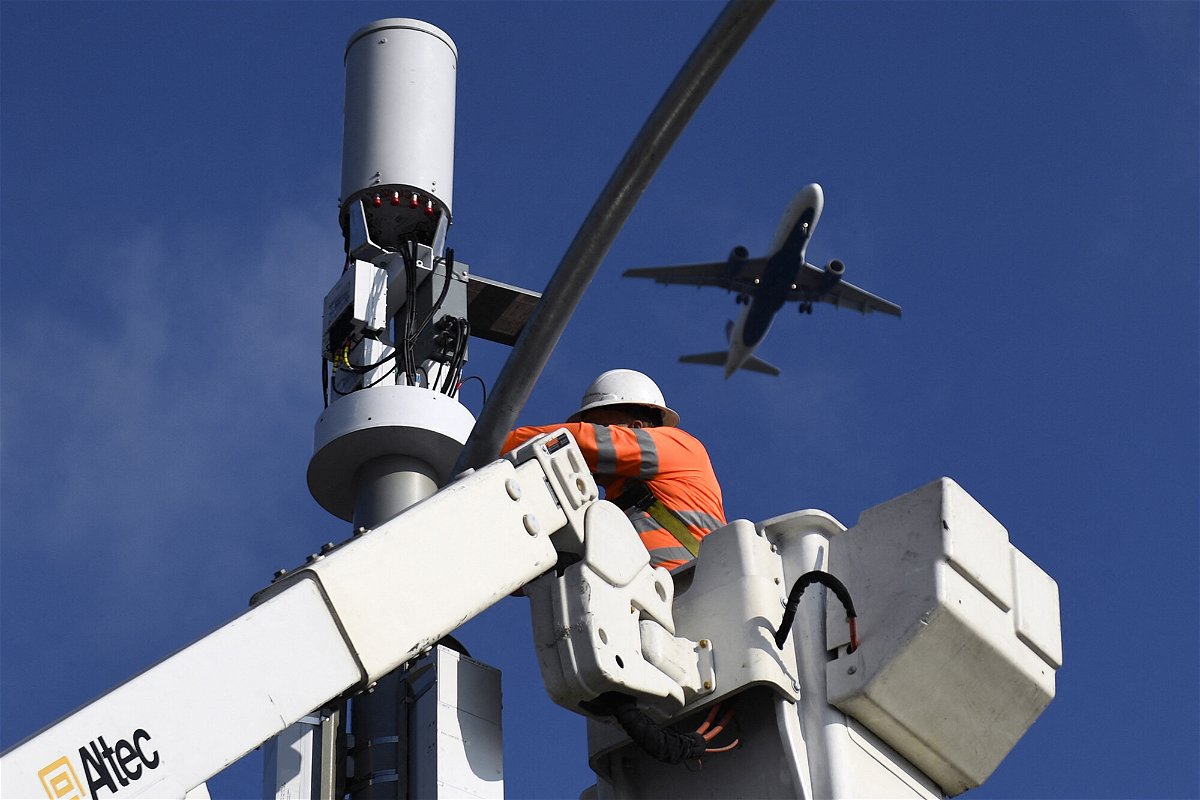 <i>Patrick T. Fallon/AFP/Getty Images</i><br/>A contractor installs 5G cellular equipment on a light pole as a Delta Air Lines