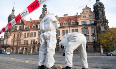 Two members of the forensic team are standing in front of the Residence Palace with the Green Vault behind a barrier tape. Dresden's Treasury Green Vault was broken into