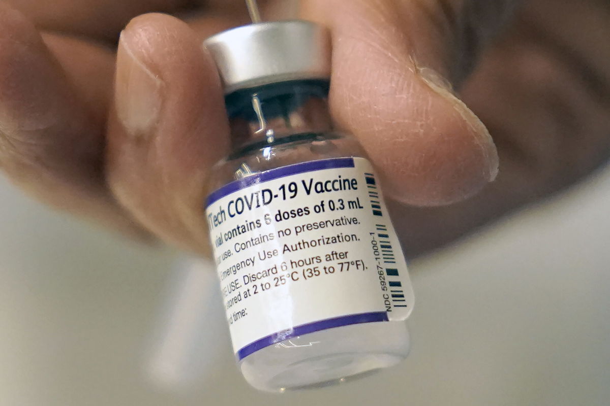 <i>Steven Senne/AP</i><br/>A doctor loads a dose of Pfizer Covid-19 vaccine into a syringe